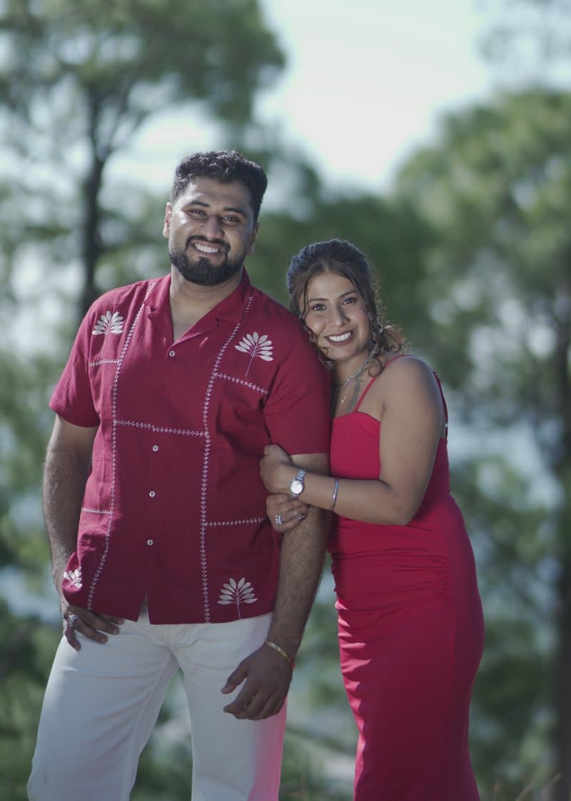 Samriti and Sarthak smiling among the pines